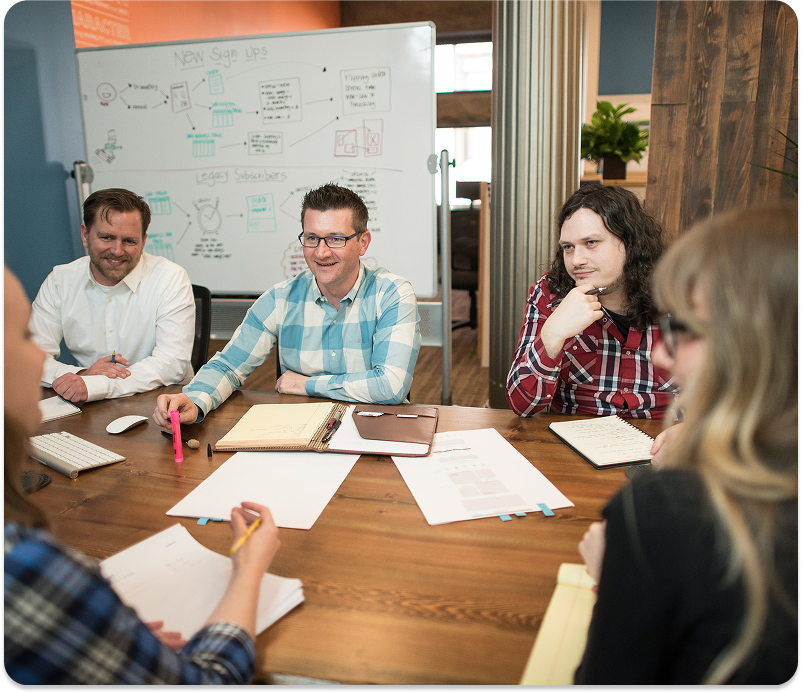 built mighty teamat conference table discussing woocommerce seo services